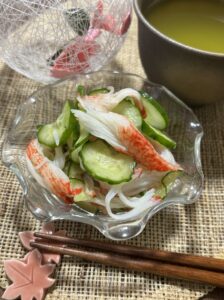 Refreshing Japanese Cucumber and Crab Stick Sunomono served in a bowl, garnished and ready to enjoy at home.シャキシャキきゅうりとカニカマの酢の物、器に盛り付けられた完成形の日本の家庭料理。